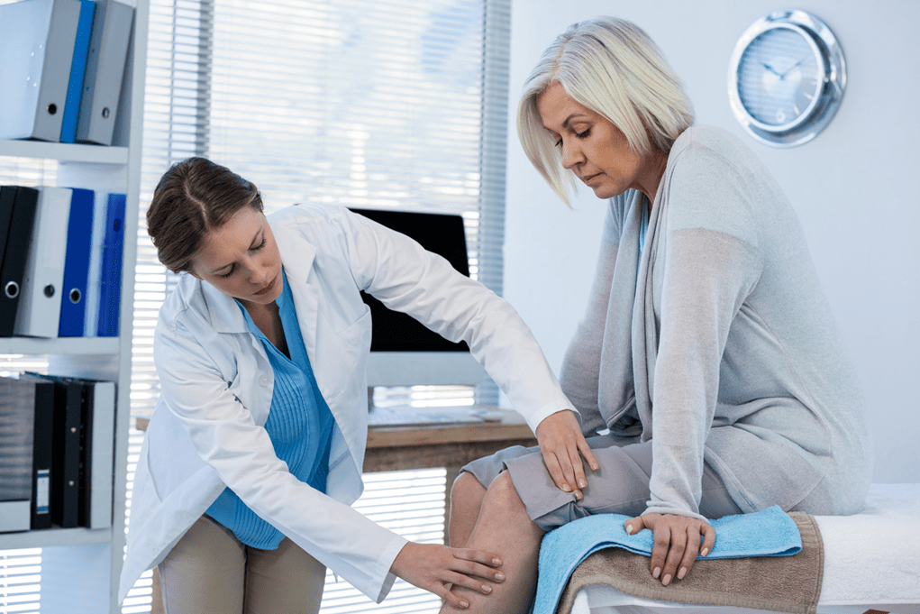 Alaisan ti o ni arthrosis ti o nilo itọju ailera ni ayẹwo nipasẹ dokita kan